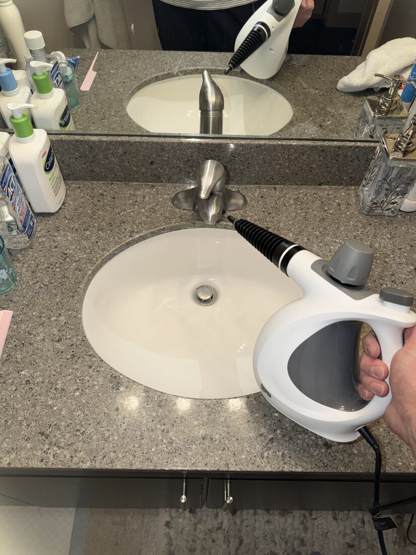 Steam cleaning a bathroom faucet and sink with the Velmora